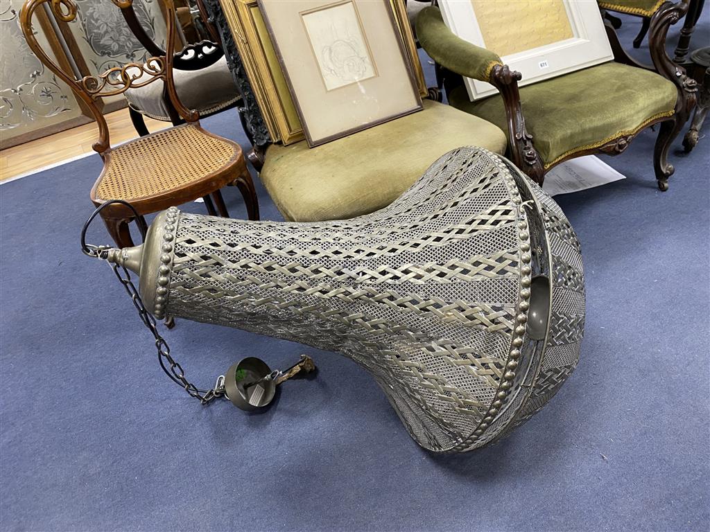 A large pierced metal ceiling shade